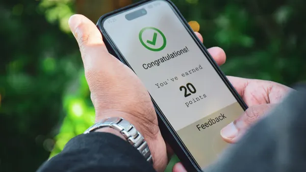 A person receives a message that they've earned loyalty points on their phone.
