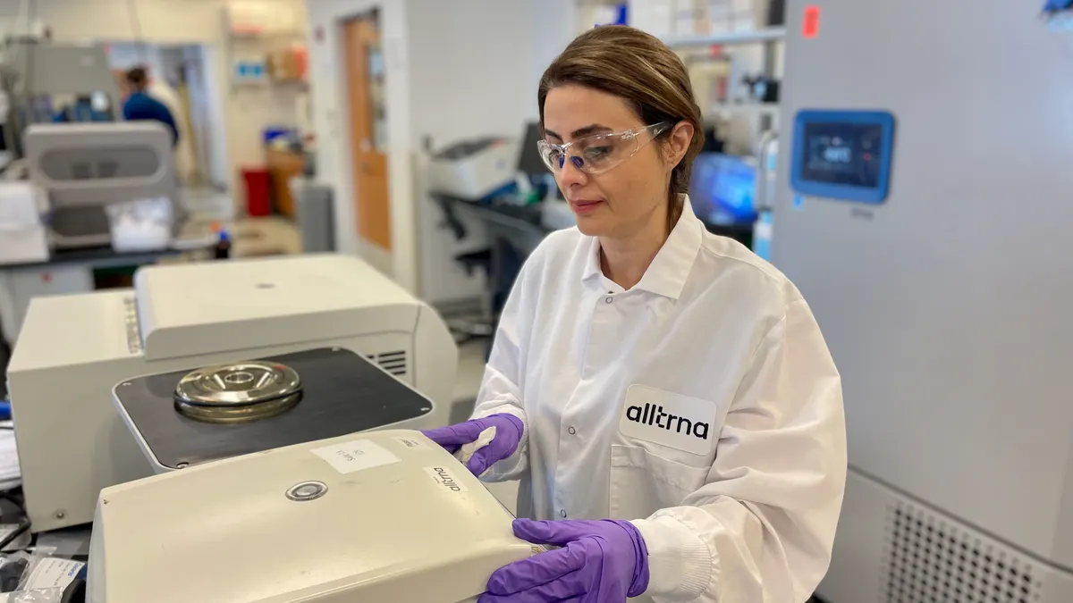 A woman uses a machine in a lab.