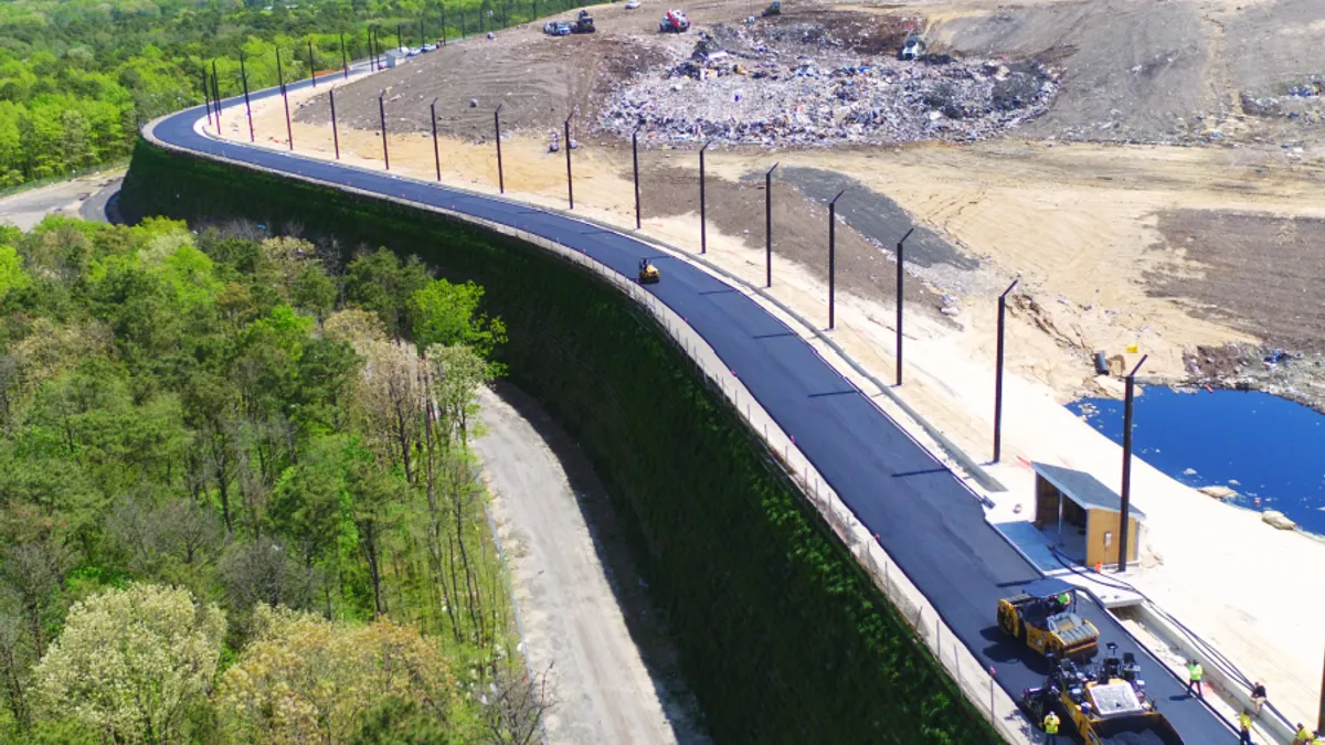 Aerial view of a berm holding in a landfill with a road running along it