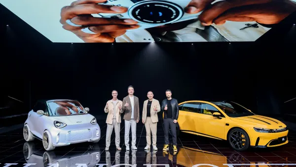 Smart Automobile Co. executives post next to a white and yellow vehicle during an event in Beijing, China.