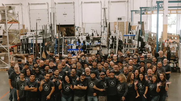 A large group of people in Awake Window & Door's manufacturing facility