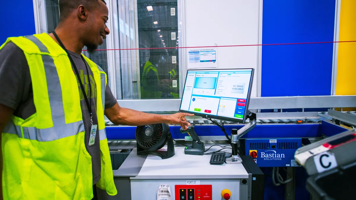 Person wearing safety vest looking at data on a computer.