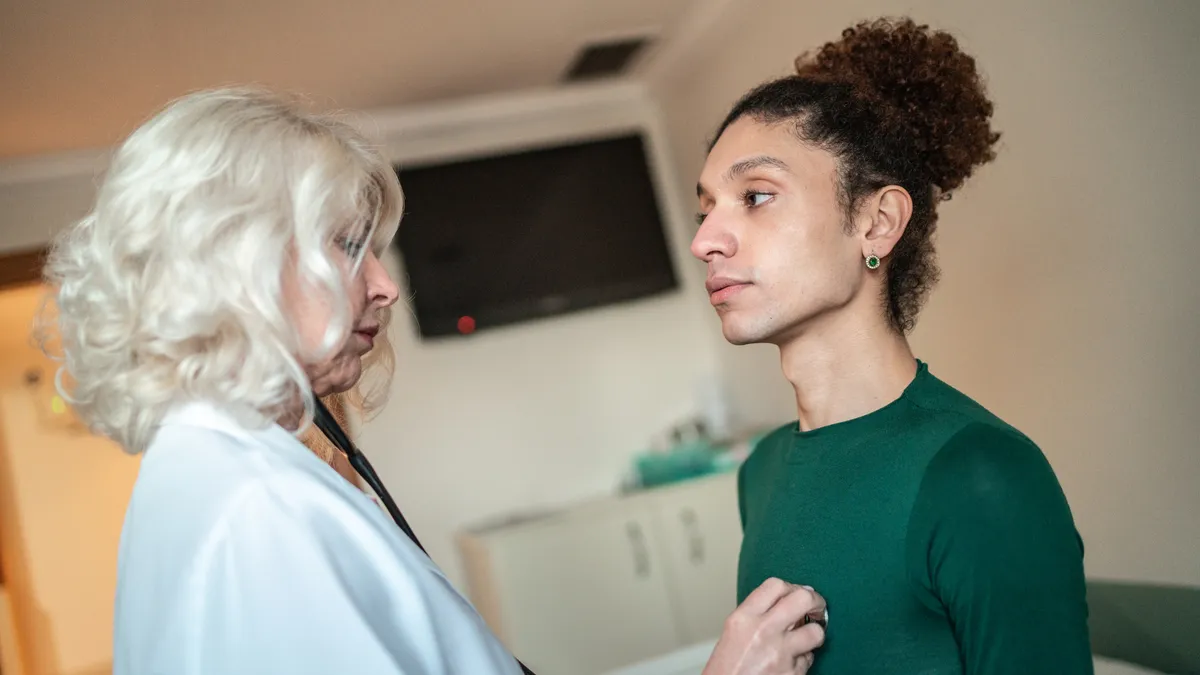 Doctor listening patient's heartbeat at hospital room