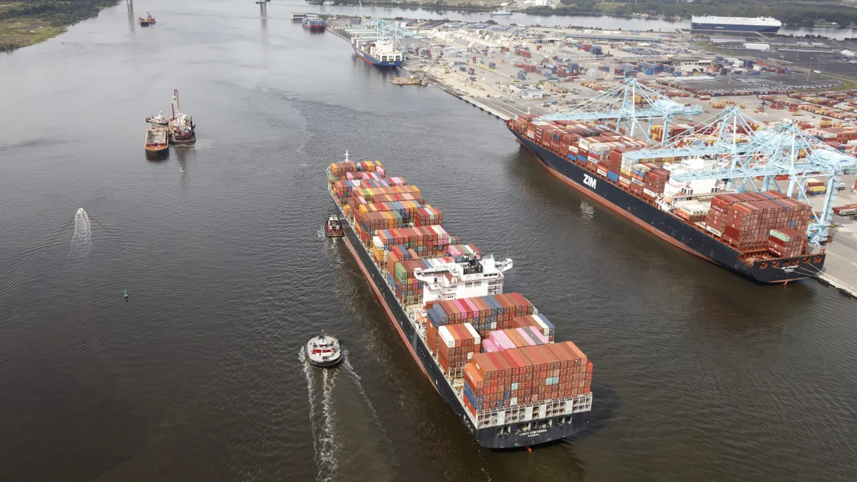 A tug boat next to a container vessel along an ocean port.