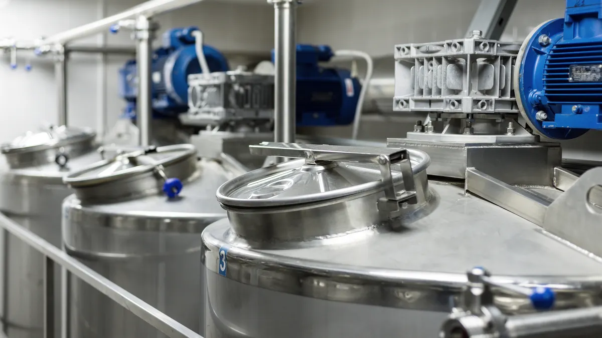 The tops of several large steel tanks, with pressure gauges and tubes running out of them.