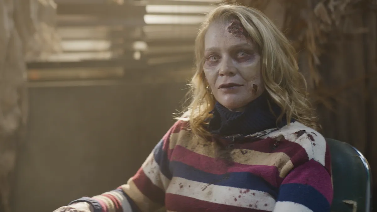 A zombie in a sweater with blond hair.