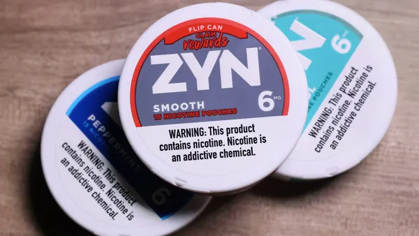 A photo of several containers of nicotine pouches. The top container says "Zyn smooth. Warning: This product contains nicotine. Nicotine is an addictive chemical."