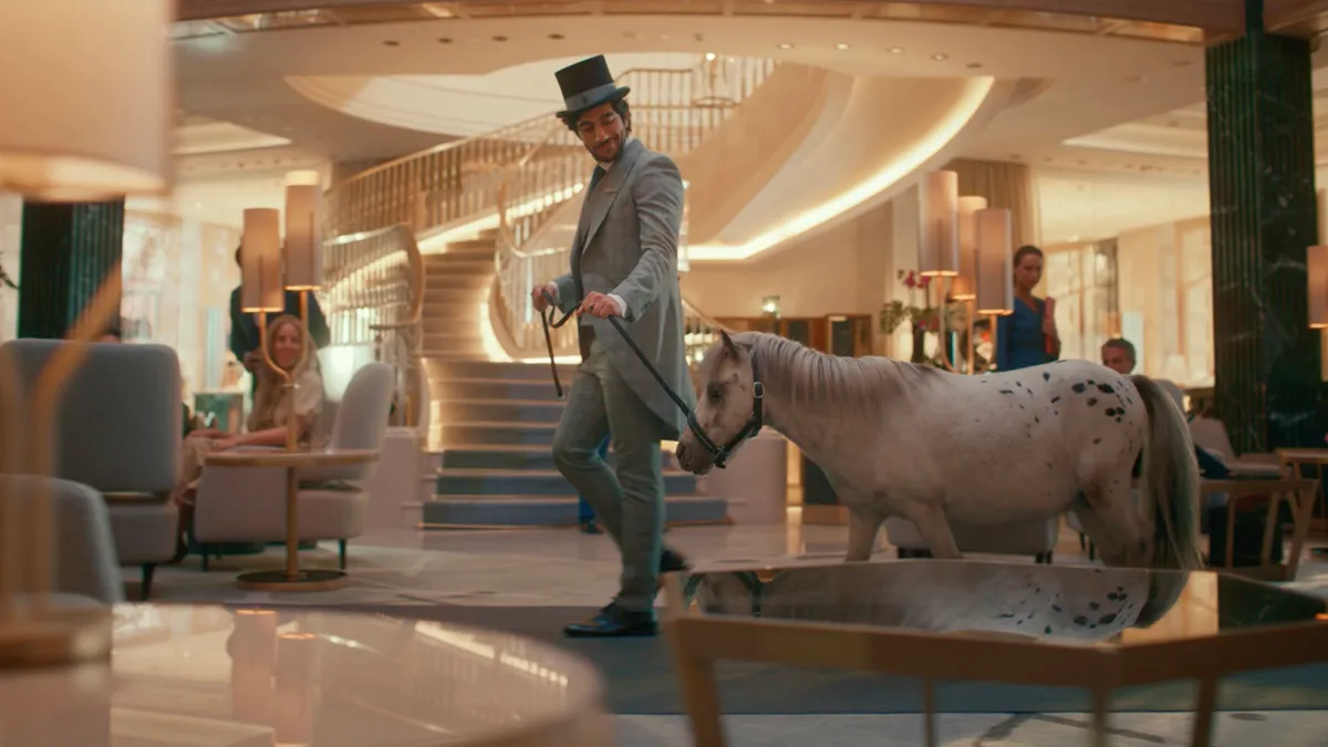 A man walks a pony through a Four Seasons Hotel as part of a new ad campaign