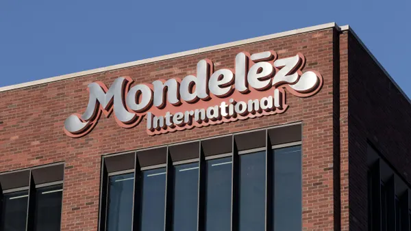 A red brick building with large windows and a bold sign reading "Mondelez International" in stylized white and pink lettering near the roofline.