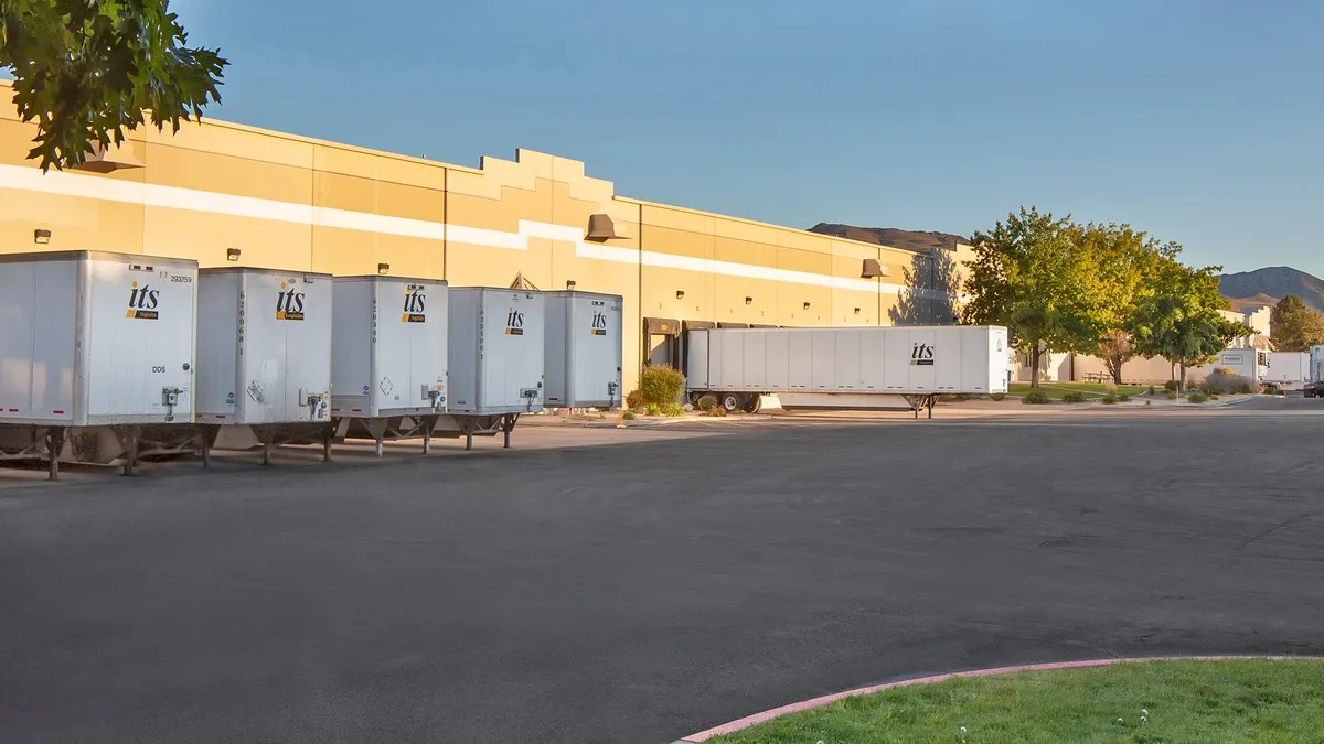 A trailer pool outside a warehouse.
