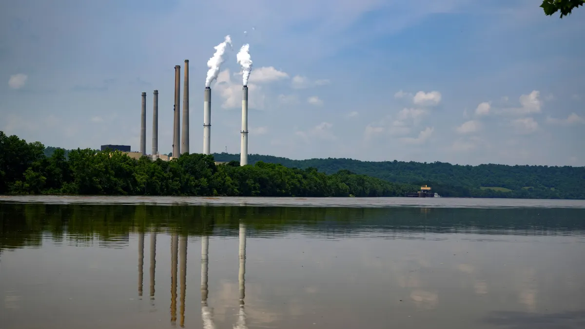 Stacks from a power plant seen next to a river.