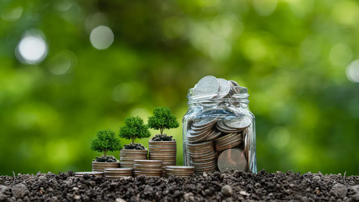 Stack of silver coins with seedlings ready to grow.