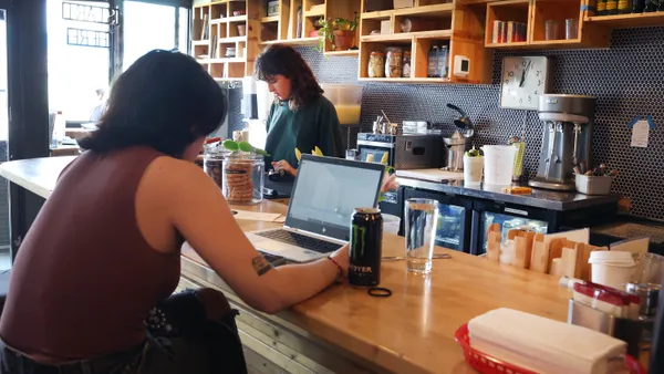 An individual workers on a laptop in a cafe.