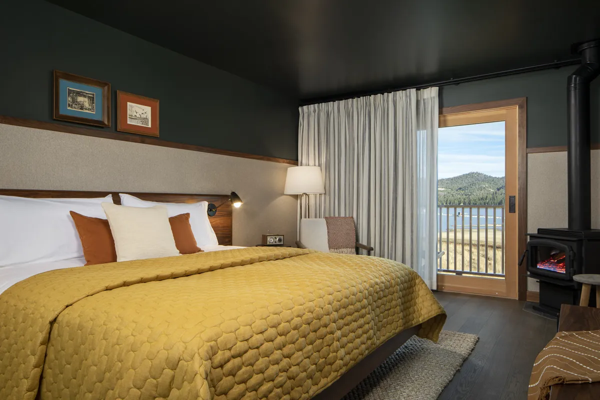 A hotel room with a bed with a yellow bedspread.