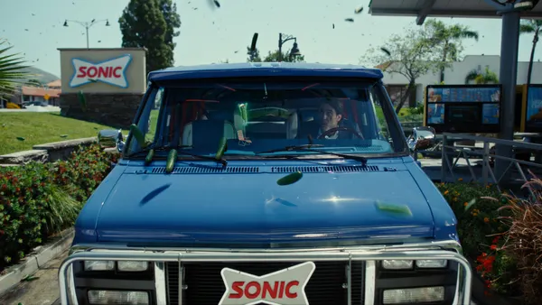 Pickles rain down on the top of a car in an ad from Sonic Drive-In