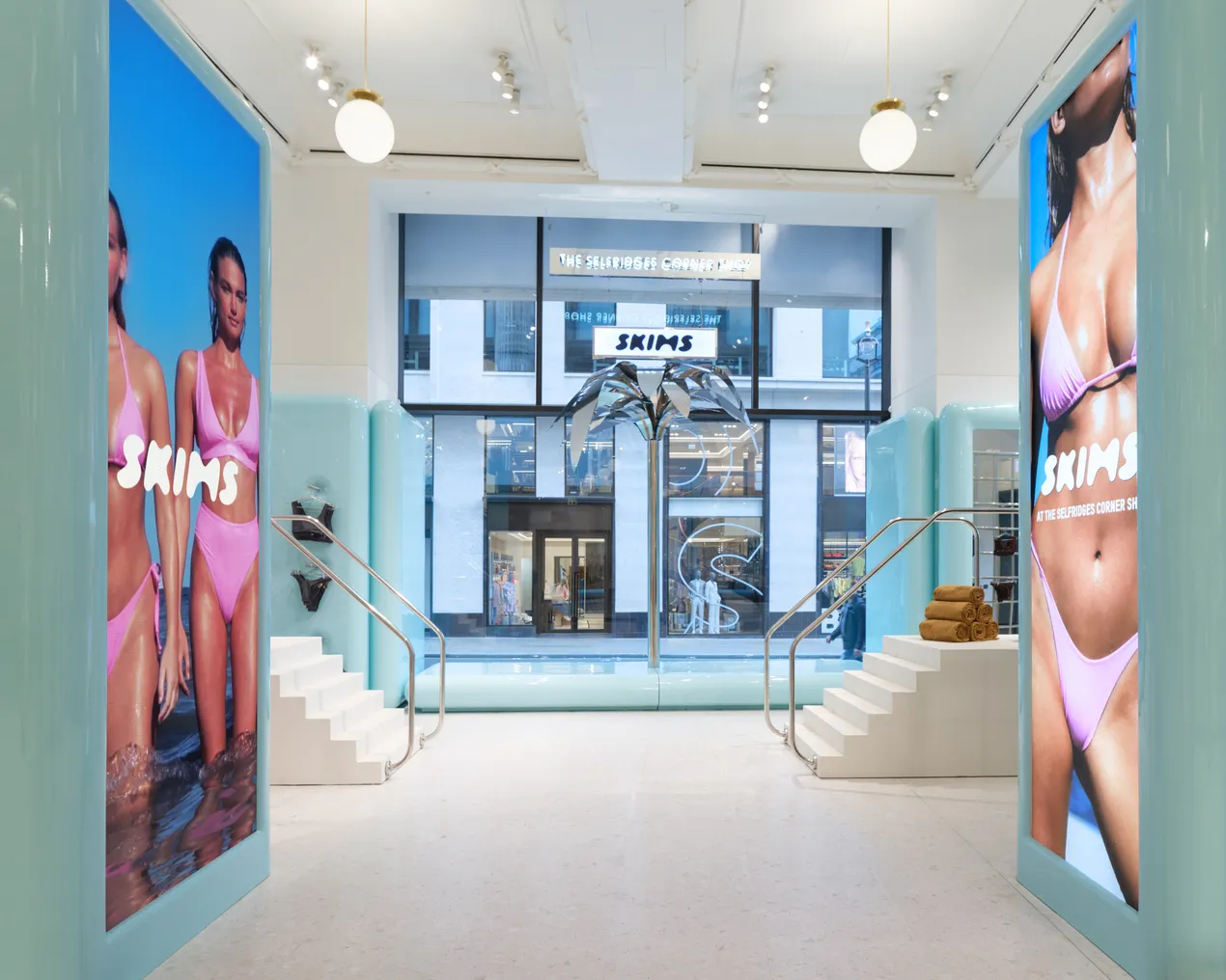 A blue and white Skims pop-up shop in London featuring pink bikini imagery