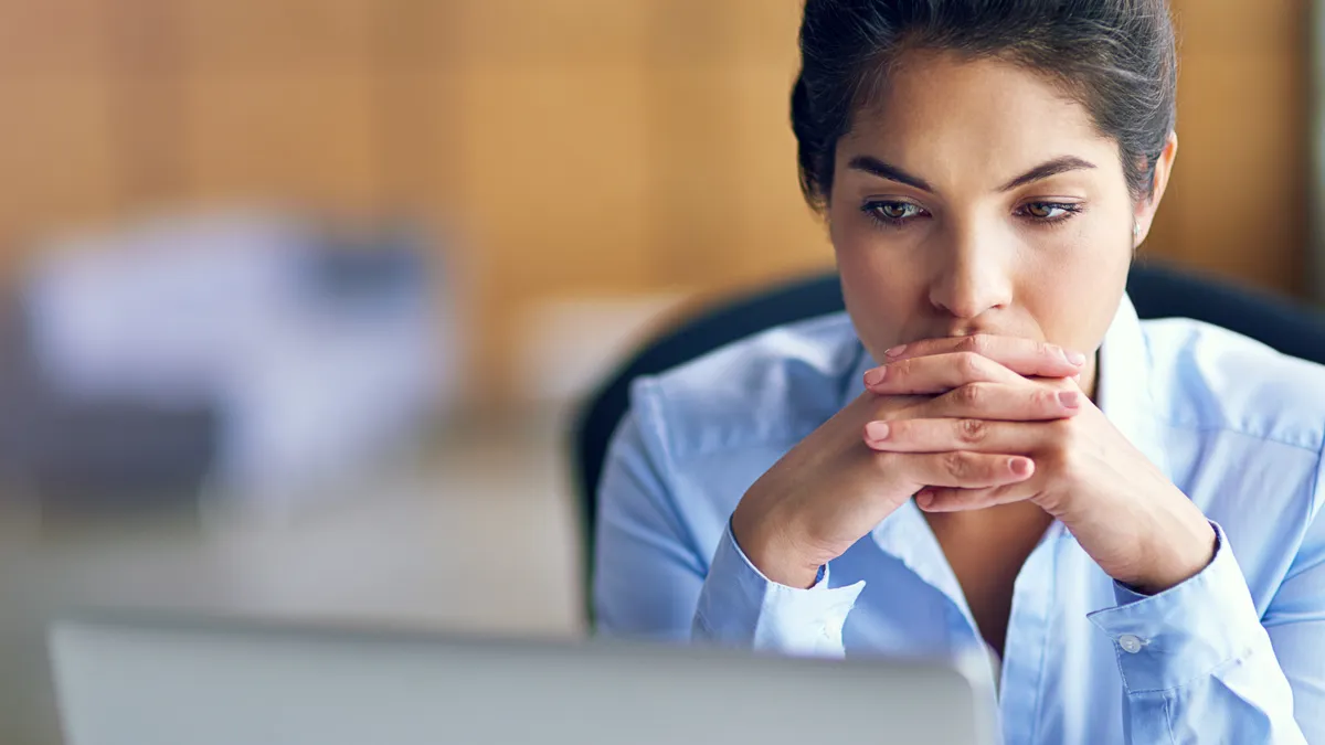 A woman looks distressed after a long work day.