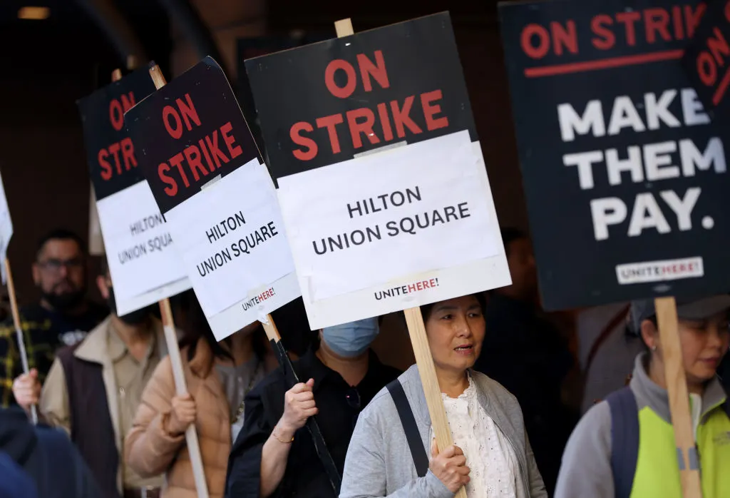Workers hold signs reading "on strike."