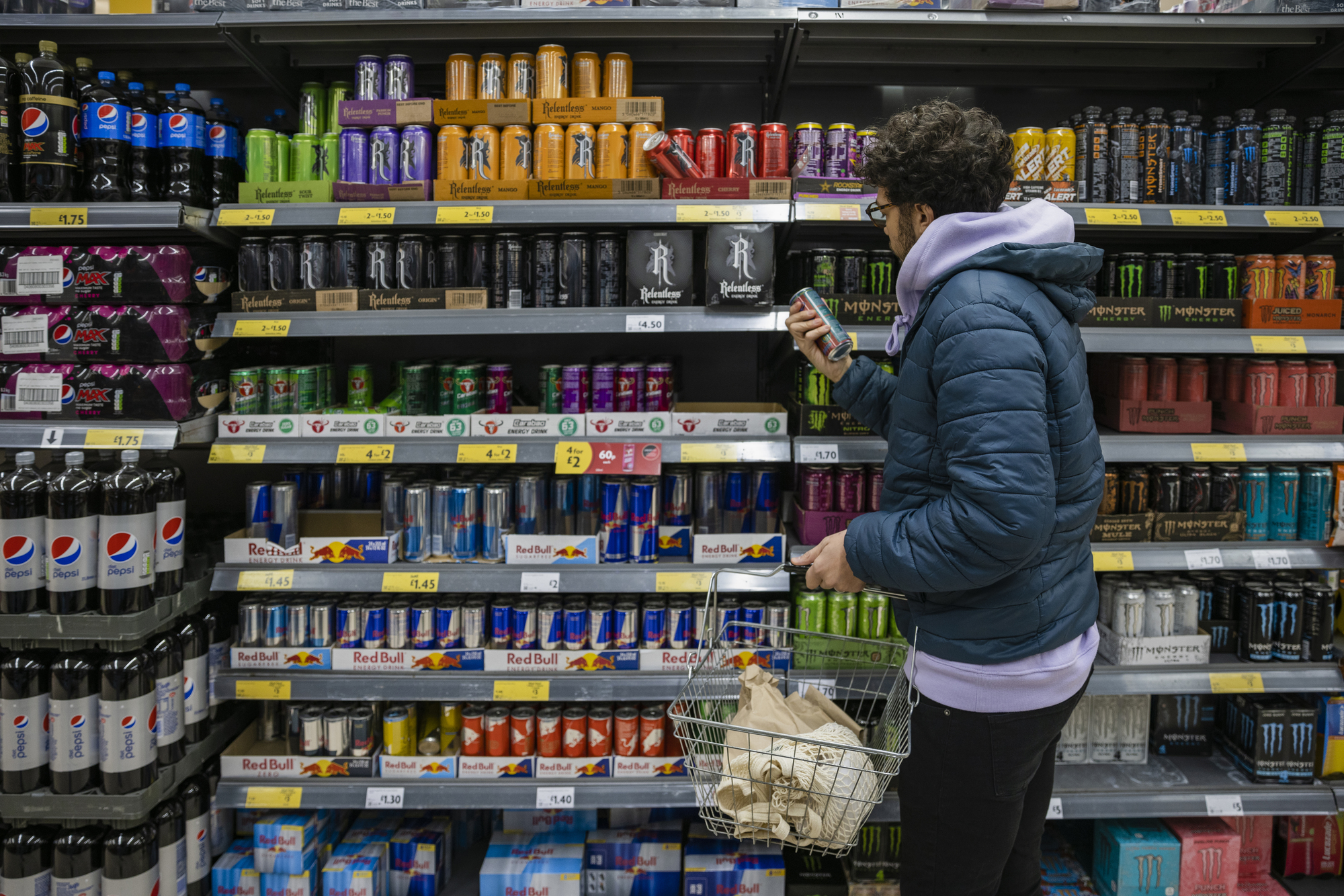 
A man browses shelves of beverages at a supermarket.