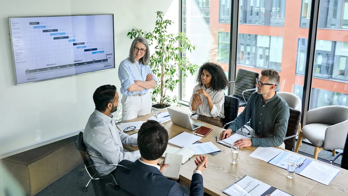 Diverse corporate team working together in modern meeting room office.