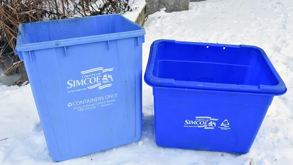 Blue recycling boxes sit in the snow