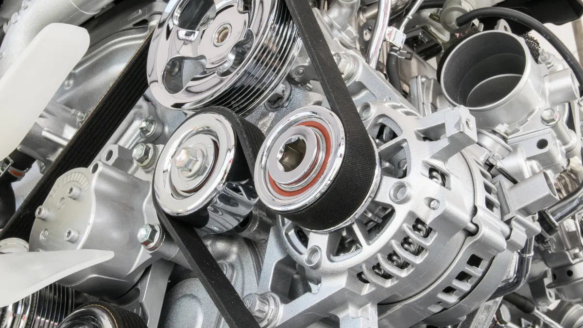 Part of silver car engine close up.