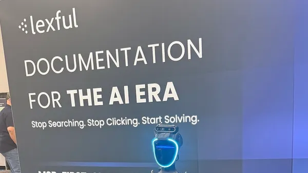 A robot stands in front of a display for Lexful at a technology conference.
