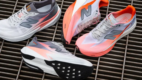 Two pairs of New Balance sneakers displayed on a grated surface.