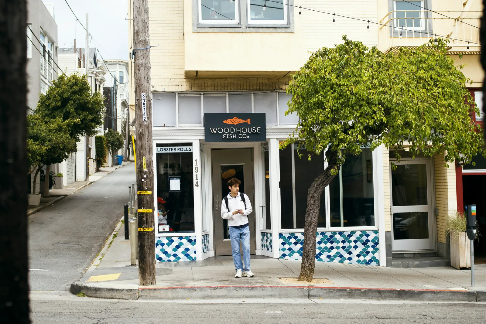 A person stands outside a seafood restaurant in San Francisco.