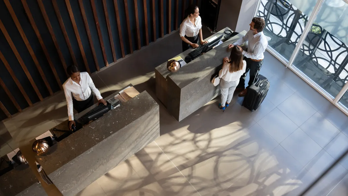 Guests check in with the front desk in a hotel lobby