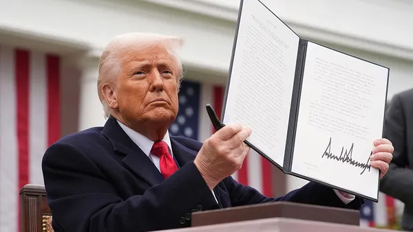 U.S. President Donald Trump holding a signed executive order imposing tariffs