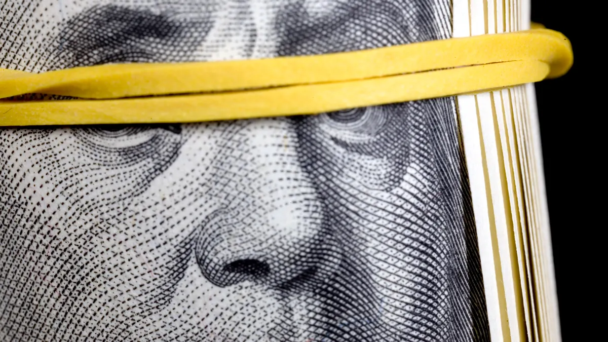 bundle of dollars with a rubber band around eyes