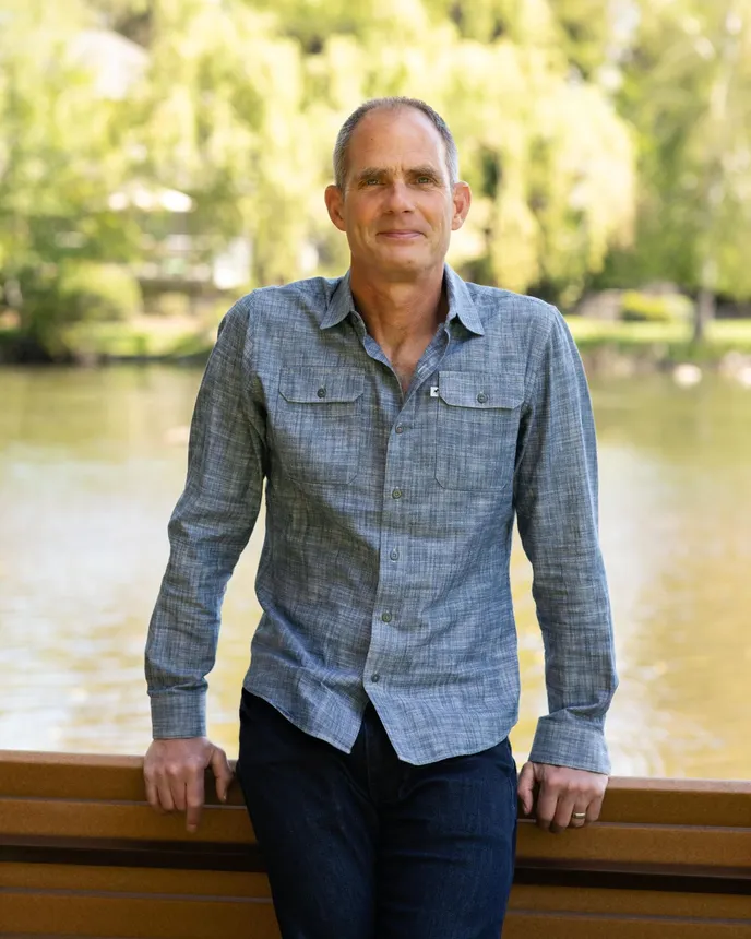 Paul Zadoff stands outdoors for a professional headshot.