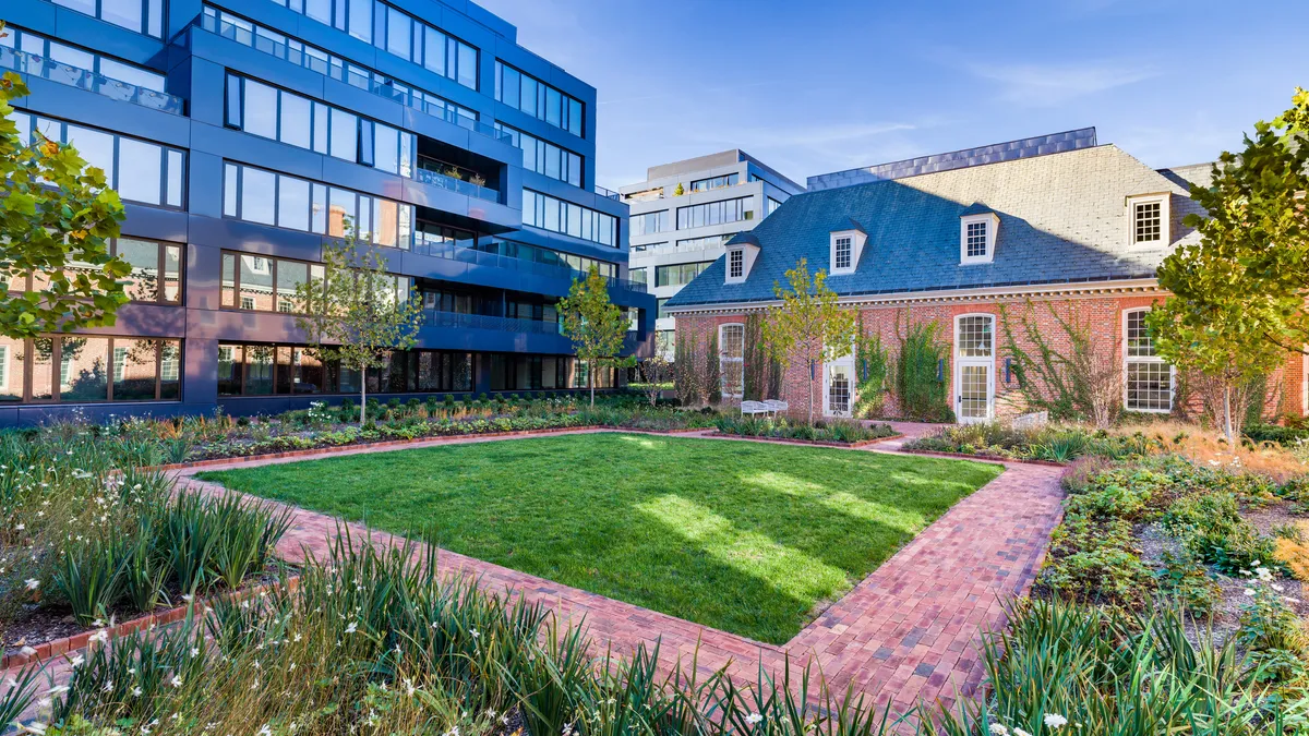 A modern apartment building situated next to a Colonial-style structure.