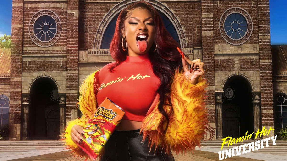 Megan Thee Stallion appears in front of the fictitious Flamin' Hot University