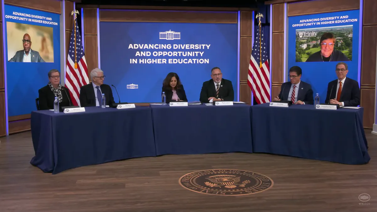 A group of college presidents and federal officials sit in front of a screen that reads "advancing diversity and opportunity in higher education."