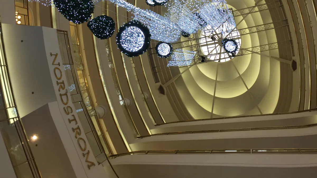 Sparkling orbs seen from below are hung in the interior of a department store.