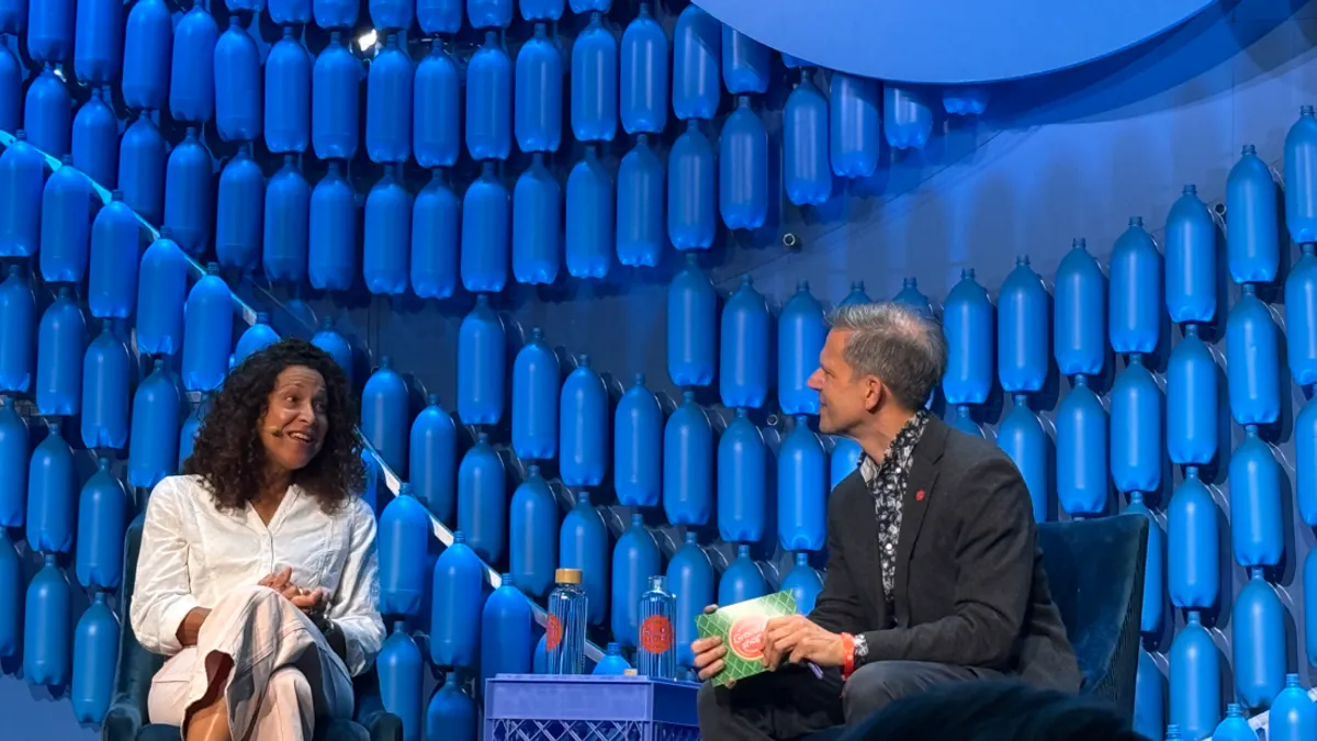 Two people speaking during a conference session.