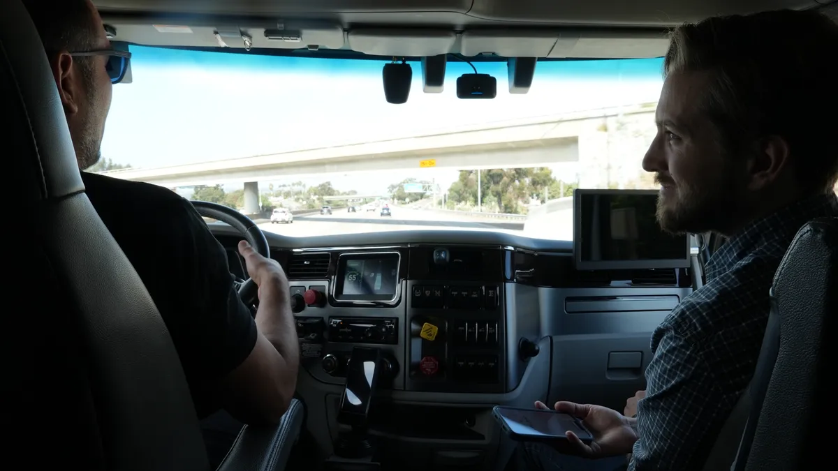 Transport Dive reporter Colin Campbell rides with driver Guztavo Martinez in a Plus semi-autonomous truck at ATA MCE 2022 in San Diego last month.