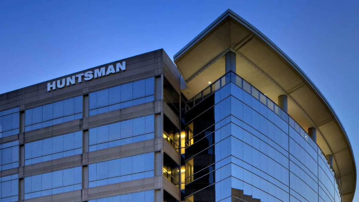 A building with windows, and the white Huntsman logo on its side.