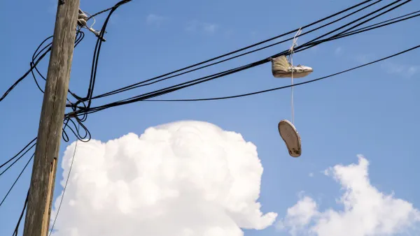 Tennis shoes hang from power lines