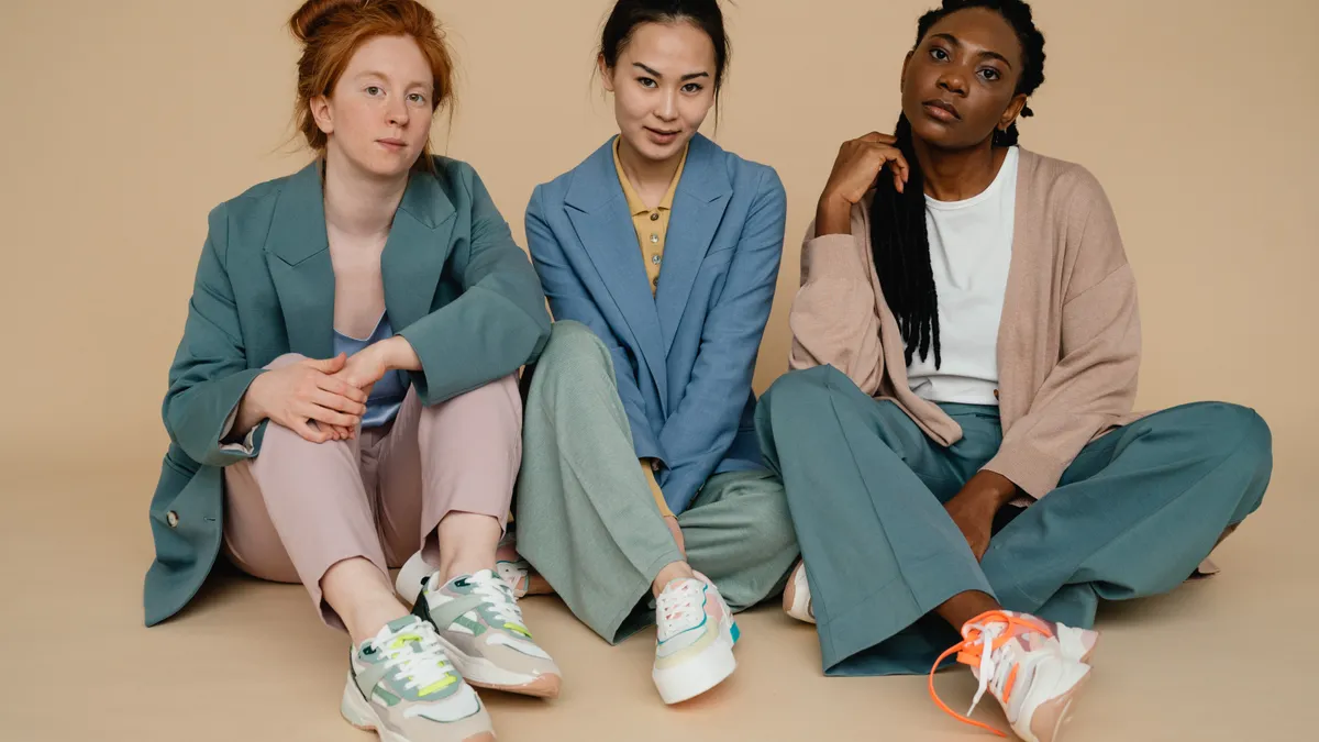 Three young people sit together in a studio