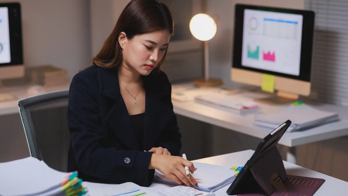 businesswoman working late night reviewing documents