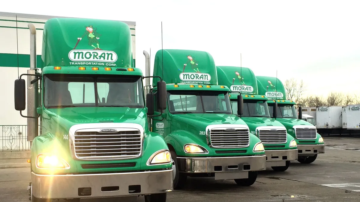 Four Moran Transportation trucks parked in a row.