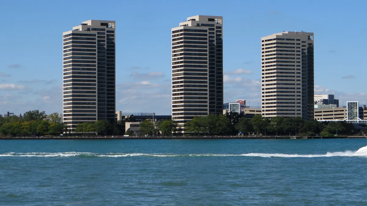 White towers with a river in the foreground.