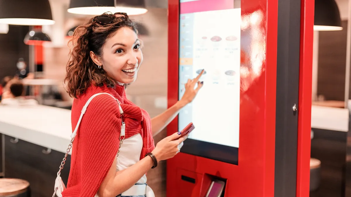 Woman infront of kiosk.