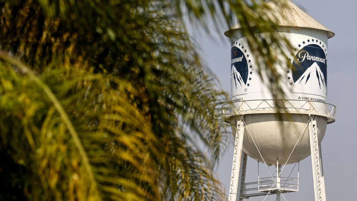 A water tower with the Paramount logo hides behind palm fronds