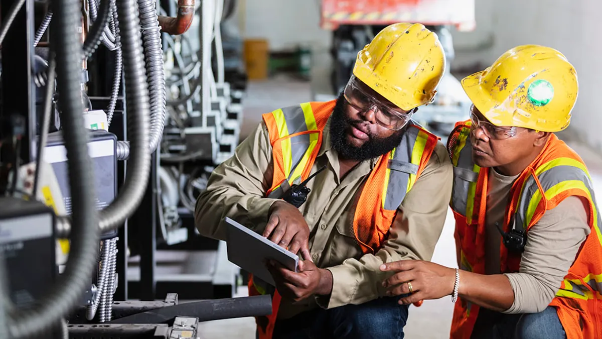 Two workers inspecting industrial refrigeration equipment