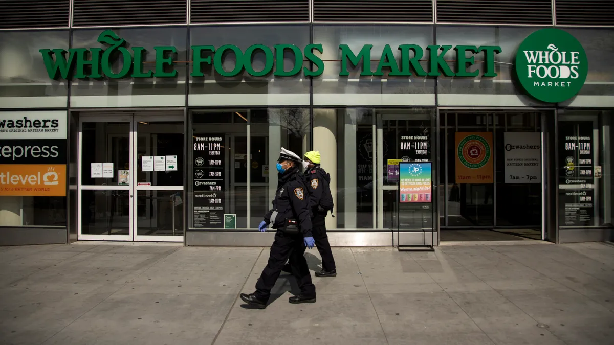 Two New York City Police Department Traffic Enforcement agents walk past the Whole Foods Market