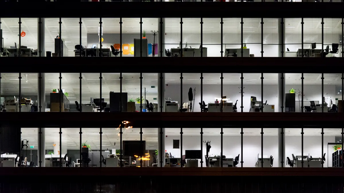 Detail of an office building in the night, illuminated with indoor lights.